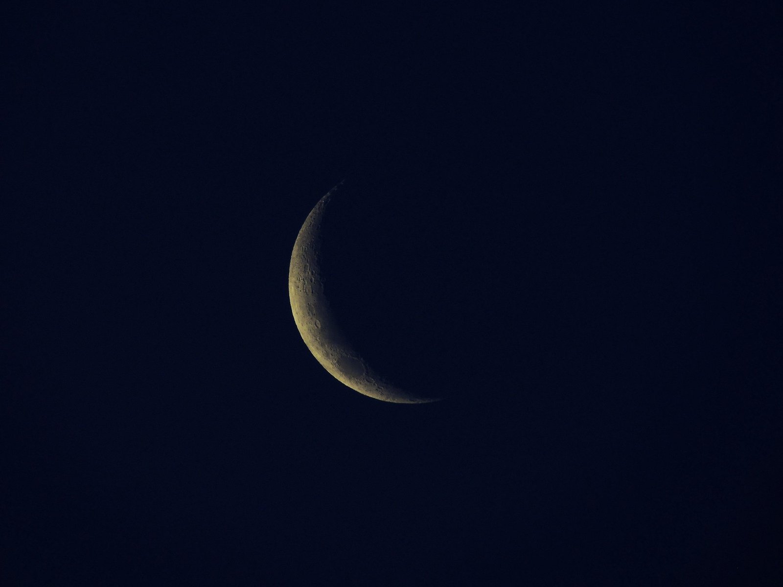 A serene view of a crescent moon against a dark night sky, symbolizing tranquility.